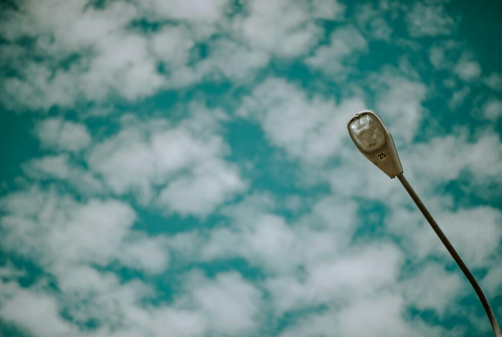 Low-angle photo of a streetlight against a cloudy sky, emphasizing a serene outdoor atmosphere.